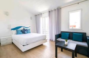 a bedroom with a bed and a couch at Marina Holiday House in Quarteira