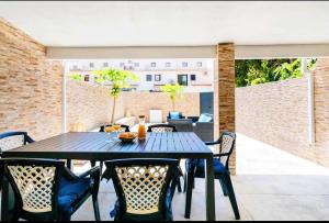 a dining table and chairs on a patio at Marina Holiday House in Quarteira