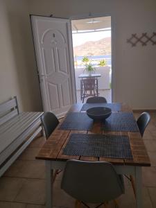 - une salle à manger avec une table et des chaises en bois dans l'établissement Meltemi, à Posidhonía