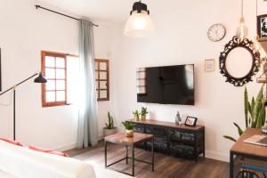 un salon avec une télévision et une table dans l'établissement Acogedor apartamento en San Andrés - Casa La Traiña, à San Andrés