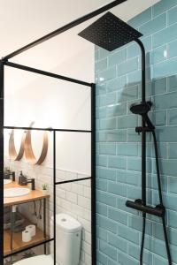 La salle de bains est pourvue d'une douche en verre avec un mur bleu. dans l'établissement Acogedor apartamento en San Andrés - Casa La Traiña, à San Andrés