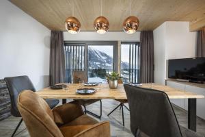 a dining room with a wooden table and chairs at Weitenmoos Panorama Apart & Rooms in Sankt Johann im Pongau