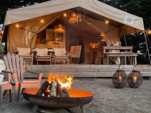 a fire pit in front of a tent at Het Blauwe Huysch in Putten