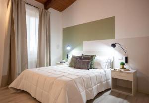 1 dormitorio con cama blanca y ventana en Chic apartment in the historic center of Perugia, en Perugia