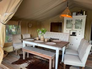 ein Esszimmer mit einem Tisch und Stühlen in einem Zelt in der Unterkunft Het Blauwe Huysch in Putten