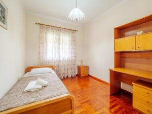 niewielka sypialnia z łóżkiem i biurkiem w obiekcie Aleka's House in Corfu Town w Korfu