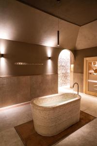 un ampio bagno con una grande vasca in una stanza di QC Termegarda Spa & Golf Resort a Calvagese della Riviera