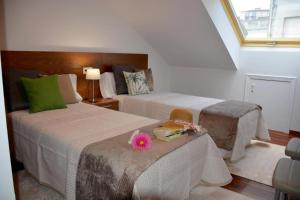 Un dormitorio con 2 camas y una mesa con una flor. en HHC - Duplex Concheiros, 4 bedrooms, 3 bathroom, a 700m de la Catedral, en Santiago de Compostela