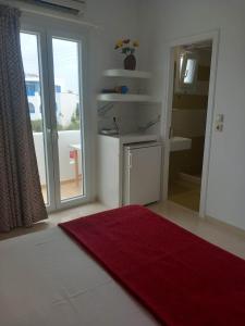 a bathroom with a red rug and a bathroom with a sink at Klimataria Studios in Agios Prokopios