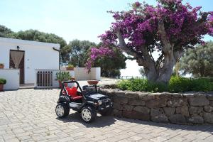 un golf cart parcheggiato accanto a un muro di pietra di Vistamare a Orosei