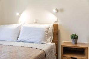 阿喬普羅柯皮歐斯的住宿－Naxian Place 2，一张带白色枕头的床和一张桌子上的植物