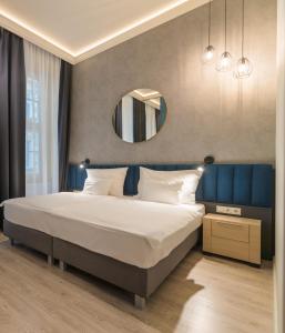 um quarto com uma cama grande e um espelho em Alta Moda Fashion Hotel em Budapeste