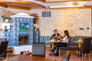 un hombre y una mujer sentados en una mesa en un restaurante en Hotel Alpino Wellness & Spa, en Peio Fonti
