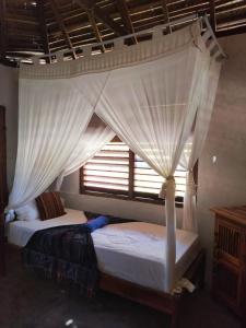 2 camas en un dormitorio con ventana en Kampung Kakak en Nembrala
