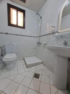 a white bathroom with a toilet and a sink at فندق الفخامة أوركيد 1 للغرف والشقق المفروشة in Makkah