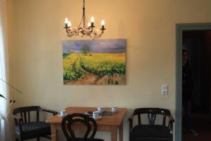 a dining room table with chairs and a painting on the wall at Ferienwohnung _Schwalbennest_ in Glave