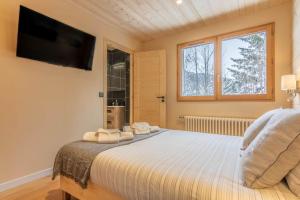 Schlafzimmer mit einem Bett und einem TV an der Wand in der Unterkunft Apartment Les Cerfs in Megève