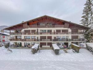 ein großes Gebäude mit Schnee davor in der Unterkunft Apartment Les Cerfs in Megève