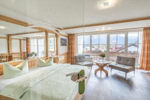 a large bedroom with a large bed and a living room at Wohlfühlhotel Frohsinn in Fischen