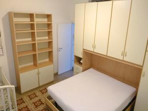 - une chambre avec des armoires blanches et un lit dans l'établissement Grottammare mon amour Ponente, à Grottammare