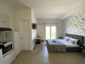 a bedroom with a bed and a kitchen with a stove at Ai Nies Studios in Soúrpi