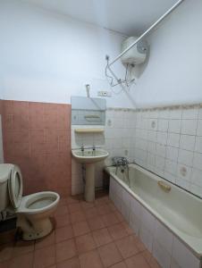 a bathroom with a toilet and a sink and a tub at Shiranthi Guest House in Rajagiriya
