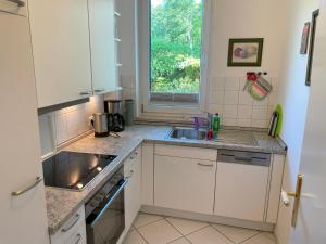 a kitchen with white cabinets and a sink and a window at Apartment Helena mit 2 Terrassen in Zempin