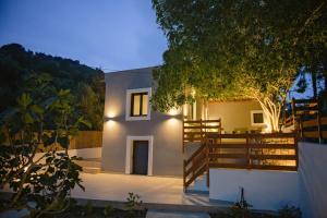 a white house with a wooden fence and a tree at River House in Kalymnos