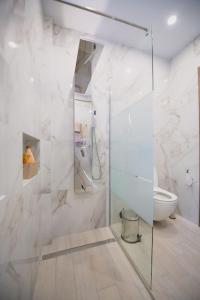 a bathroom with a glass shower stall and a toilet at River House in Kalymnos