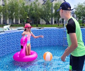 a boy and a girl playing in the water on an inflatable at Apartamenty Lambert Grzybowo in Grzybowo