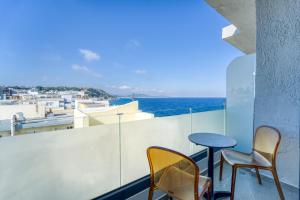 2 sedie e un tavolo sul balcone con vista sull'oceano di Island Sea Side Hotel - Adults Only a Città di Rodi