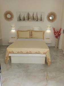 a white bed in a room with two mirrors at Klimataria Studios in Agios Prokopios