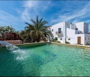 a swimming pool in front of a white house at Villa Elena in Sant Josep de Sa Talaia