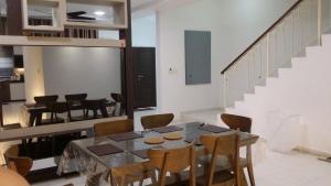 a dining room with a table and chairs and a staircase at Cosy Spacious Homestay in Central Batu Pahat with Wifi & GENTING Clubhouse in Kampong Seri Gading