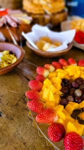 uma mesa coberta com frutas, bagas e pratos de alimentos em Fazenda Quinta da Esperança- Pousada e Lazer em Tiradentes
