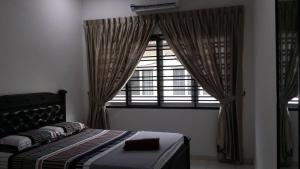 a bedroom with a bed in front of a window at Cosy Spacious Homestay in Central Batu Pahat with Wifi & GENTING Clubhouse in Kampong Seri Gading +56 photos