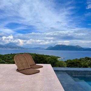 a pair of chairs sitting on the edge of a pool at Mirazur in Meganisi