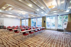 een vergaderzaal met tafels en stoelen en een podium bij ACHAT Hotel Karlsruhe City in Karlsruhe