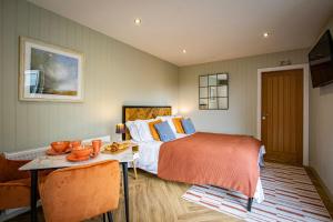 ein Schlafzimmer mit einem Bett und einem Tisch darin in der Unterkunft Comfy Lake District Cabins - Winster, Bowness-on-Windermere in Winster