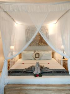 - une chambre avec un lit blanc à baldaquin dans l'établissement Candra Surf Homestay, à Canggu