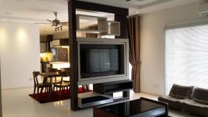 a living room with a flat screen tv on a entertainment center at Cosy Spacious Homestay in Central Batu Pahat with Wifi & GENTING Clubhouse in Kampong Seri Gading