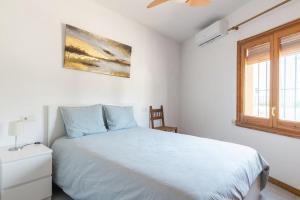 a white bedroom with a bed and a window at Seamount, a beautiful house overlooking Tamariu in Tamariu