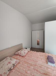 ein Schlafzimmer mit einem großen Bett mit rosa Bettwäsche und einem Spiegel in der Unterkunft Apartmani Lešić Zaklopatica in Lastovo