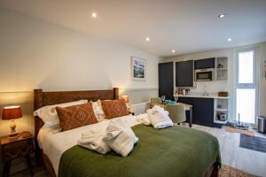 WinsterLake District Woodland Pods - Winster, Bowness-on-Windermere的卧室配有毛巾,位于床上