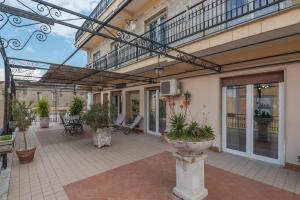 an outdoor patio with plants and a balcony at Accasatua Neapolitan Apartments in Naples
