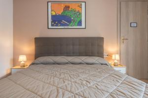 1 dormitorio con 1 cama grande y 2 lámparas en Accasatua Neapolitan Apartments, en Nápoles