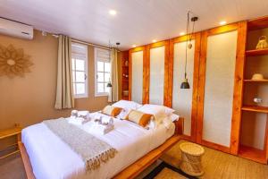 een slaapkamer met een groot wit bed in een kamer bij Ti kaz chic Deshaies in Deshaies
