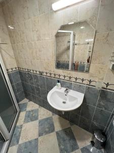 W łazience znajduje się umywalka i lustro. w obiekcie Апартамент за гости ТРАПЕЗИЦА МАК w mieście Wielkie Tyrnowo