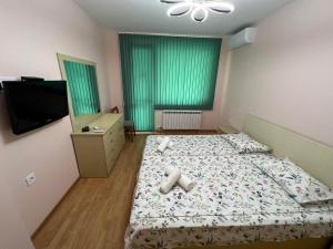 a bedroom with a bed and a dresser and a television at Апартамент за гости ТРАПЕЗИЦА МАК in Veliko Tŭrnovo +9 photos