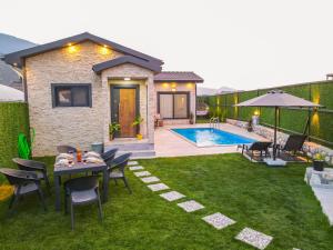 a backyard with a table and chairs and a swimming pool at Villa Atmaca in Fethiye